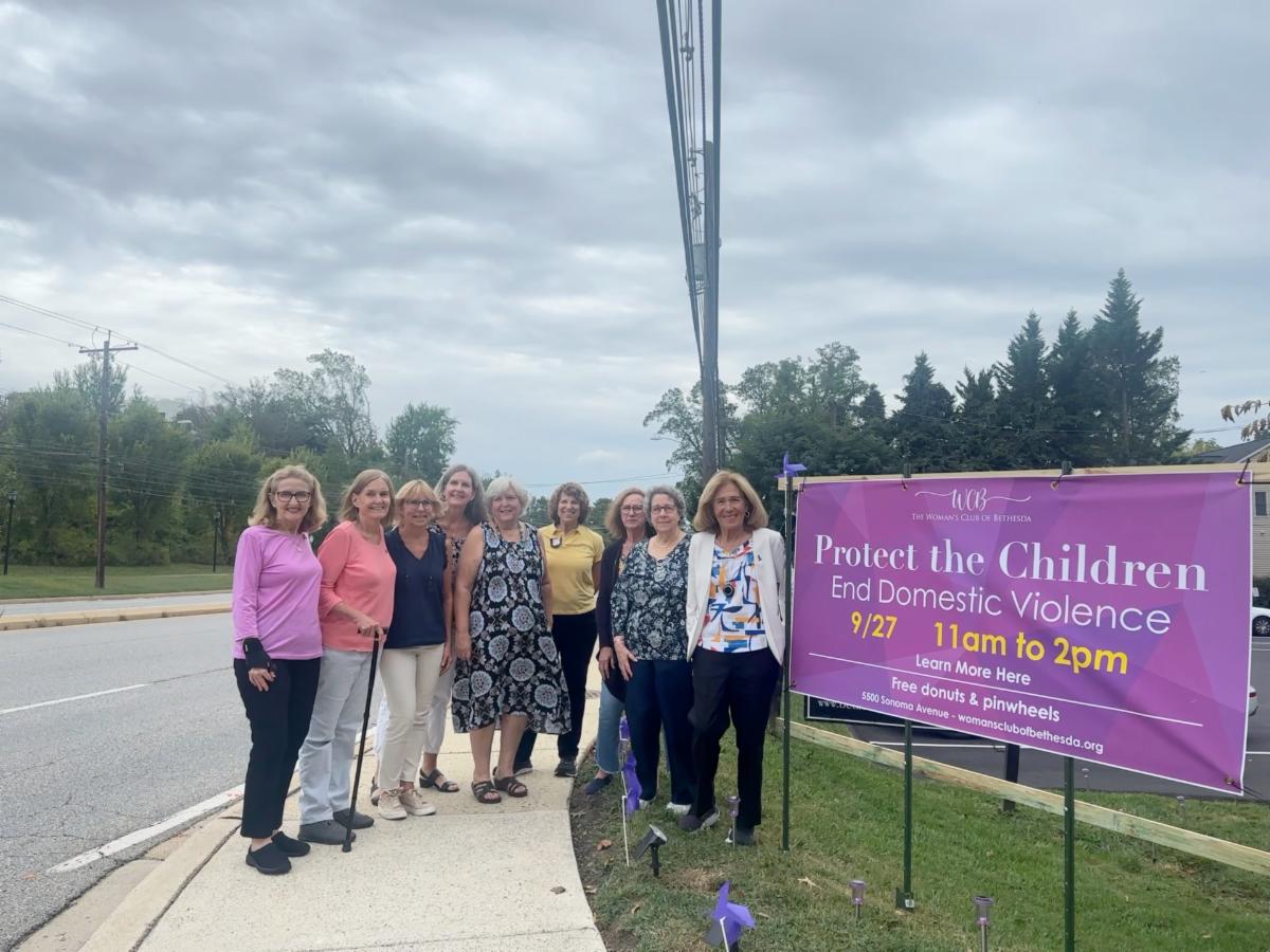 Group of people in front of the purple banner